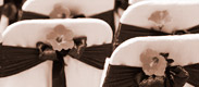 Link to wedding page. The image is a of flowers on the back of a chair.